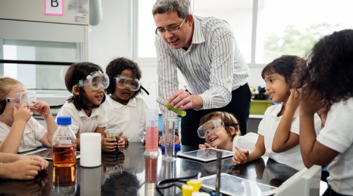 Profesor enseña quimica a algunos niños
